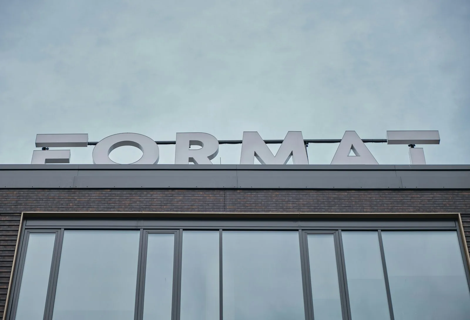 Modern office building facade with a large Format sign — Photo by Maciej Drążkiewicz on Unsplash